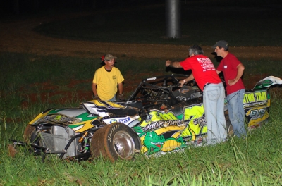 Workers check on Chris Wall's mangled machine. (Sherry Kiser)