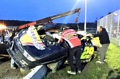 Officials remove the car of Phil Potts at Brighton Speedway. (Clayton Johns)